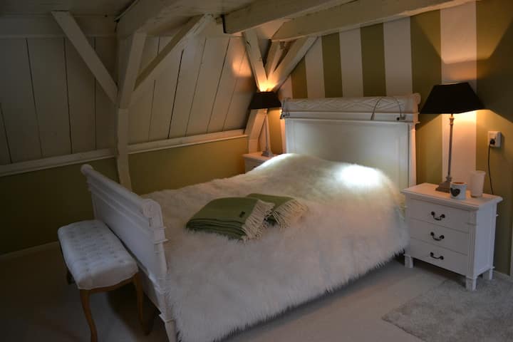 dit is het luxe witte bed in de witte kamer, die helemaal in de kleuren crème en mosgroen is uitgevoerd