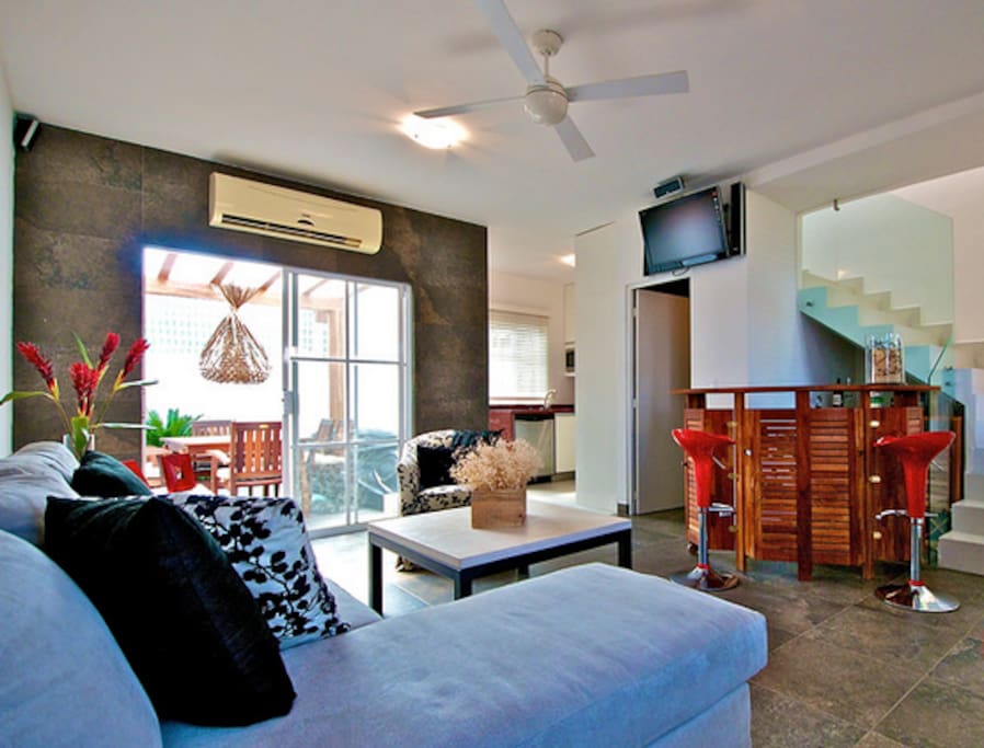 Sala de estar, cuenta con A/A, Televisión con señal satelital, reproductor de DVD home theater, medio baño, cantina, comedor y cocina al fondo.