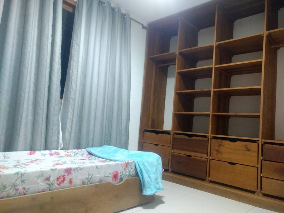 Quarto com cama de solteiro e cama auxiliar