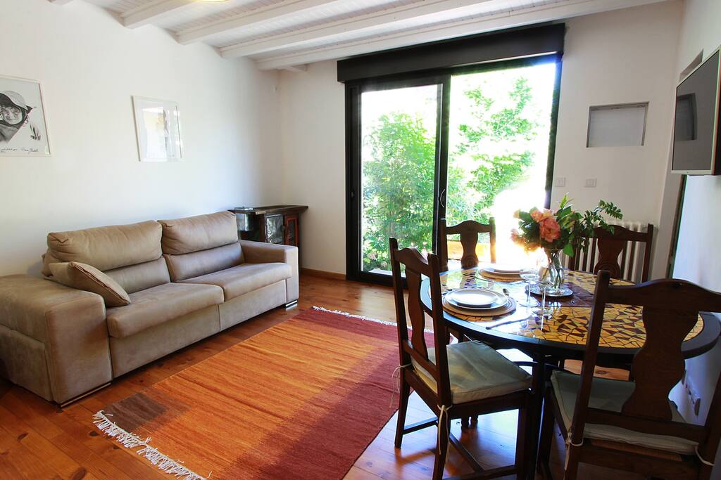 Cote salon , salle à manger: . Une baie vitrée ouvre sur une grande terrasse au milieu du jardin qui permet de se détendre à la belle saison et de prendre ses repas dehors.
