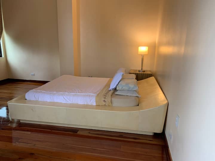 el SUite "Q" ofrece una cama tamaño queen y otro enorme espacio en el suelo para colchones plegables, baño privado y balcón privado.