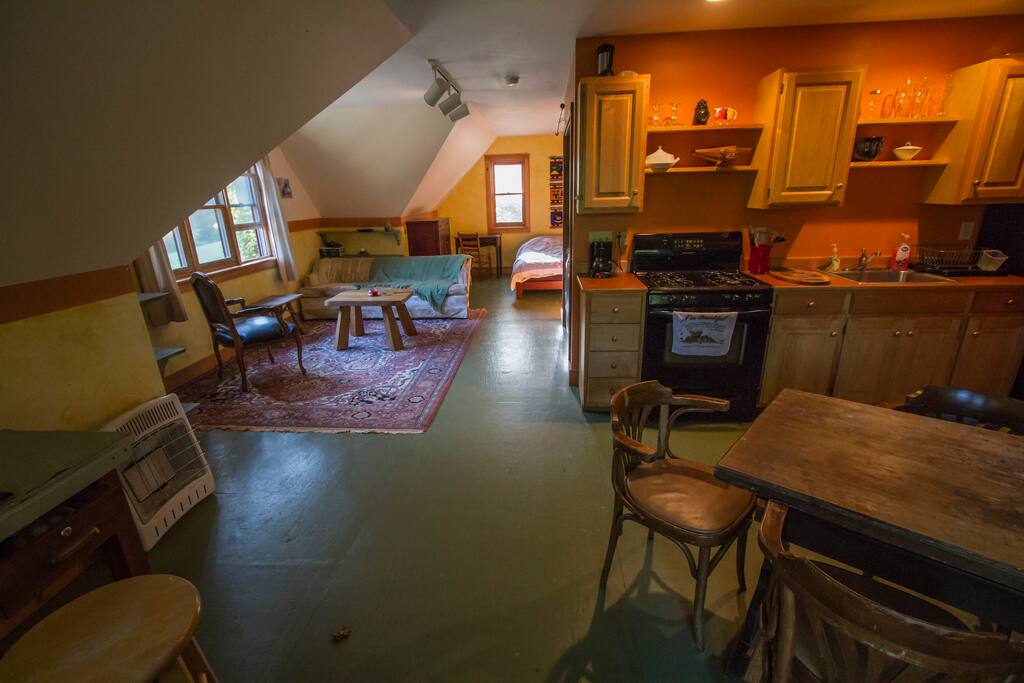 The apartment view from the entrance. It is an open, loft-style apartment with kitchen, living area, and sleeping area.