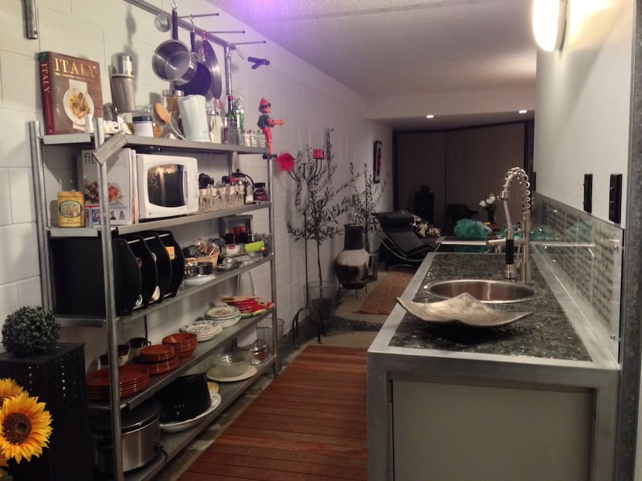 Cafe kitchen with duck board floor, steel bench, black stone bench top, funky cafe tap.