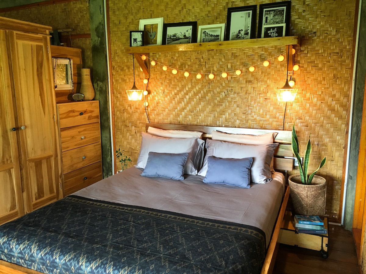 Na poschodí domu na strome The Writers 'Treehouse sa nachádza pohodlná menšia manželská posteľ s výhľadom na kopce džungle.