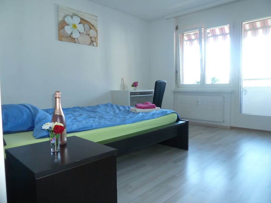 sleeping room with double bed with excit to the balcony, closet, desk and chair