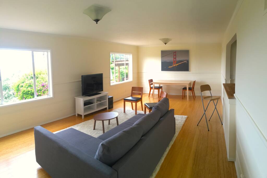 The living room with views, full sized sofa bed, TV, dining table, and kitchenette.