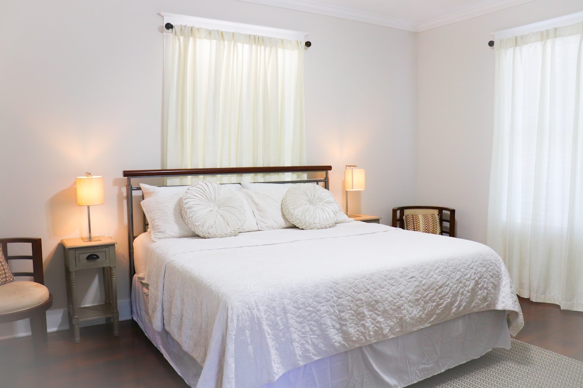 ห้องนอนใหญ่ขนาดใหญ่พร้อมเตียงคิงไซส์และพื้นที่นั่งเล่น