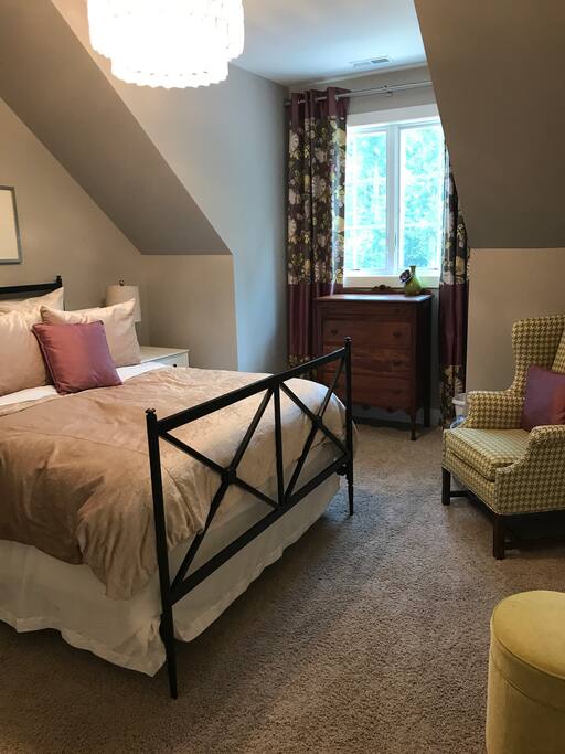 Private bedroom with queen bed, extra pillows, blackout curtains, fan, phone charger and plenty of storage
