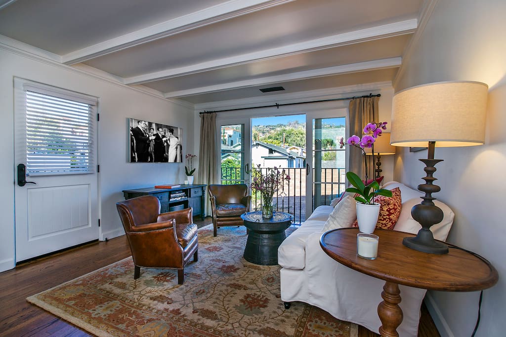 Living room with large flat screen TV with DVD player, sliding doors with view towards Santa Barbara Riviera