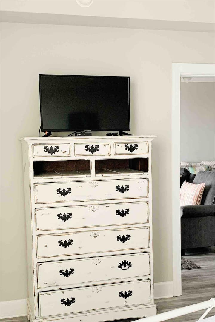 หีบลิ้นชักและทีวี 32 นิ้วในห้องนอนใหญ่
 