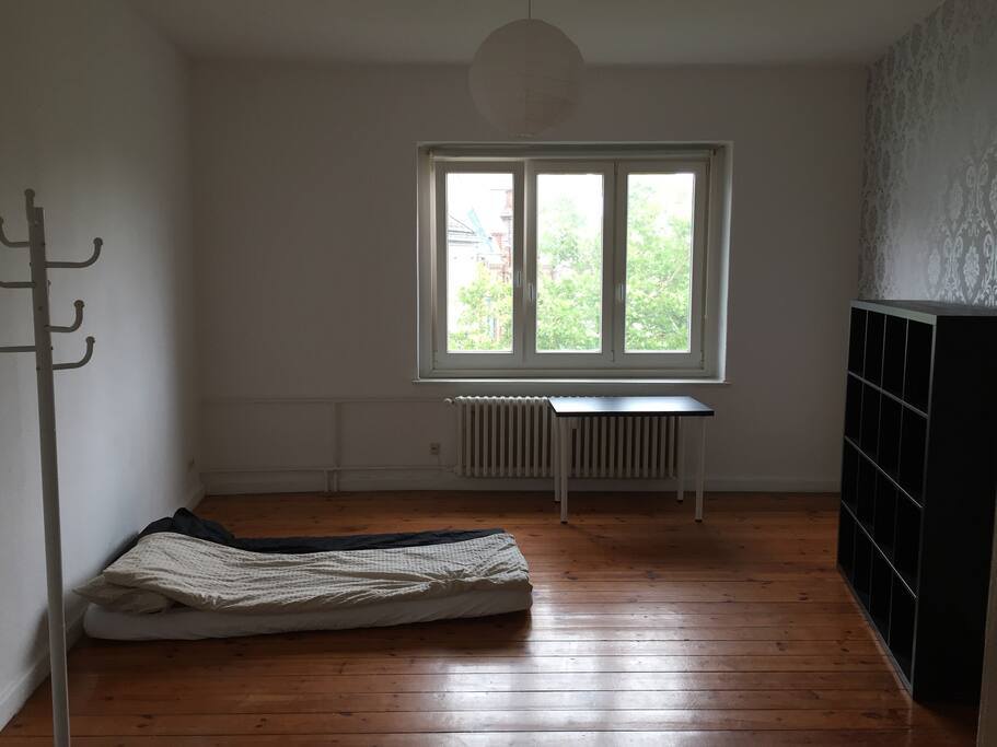 Schlafzimmer
Es ist ein wunderschönes und fast 22 qm großes Zimmer. Wie auf dem Bild zu sehen ist, steht kein Bett in dem Zimmer, sondern es liegt dort eine Matratze mit frischer Bettwäsche.
Morgens wacht man zusammen mit der aufgehenden Sonne auf und hat beim Frühstück einen erfrischenden Blick auf die Fußgängerzone am Alten Markt.
Trotzdem müssen die Langschläfer keine Angst davor haben, dass die Sonne sie morgens weckt Es ist ein Rollo über die gesamte Breite des großzügigen Fensters installiert.
Was es sonst noch über das Zimmer zu sagen gibt:
Auf der rechten Wand, wenn man ins Zimmer kommt, ist eine königlich silbern schimmernde Tapete angebracht (siehe Bild) und Steckdosen sind im Überfluss vorhanden! (9 Stück)
Das Herz von Kiel: Alter Markt! Hier findest du alles, was du zum Leben brauchst und alles ist in wenigen Minuten zu Fuß erreicht.
Morgens kannst du dir einen frischen Apfel beim Obsthändler um die Ecke kaufen, den Wocheneinkauf erledigst du entspannt bei Rewe (3 Minuten), shoppen kannst du in der gesamten Holstenstraße (3 Minuten) und du gehst abends gern mal mit Freunden etwas trinken? Kein Problem! Ein Mal stolpern und ihr seid in der Klosterbrauerei oder im Mango´s.
Die Studenten unter euch sind innerhalb von 15 Minuten mit dem Bus in der Uni.
Die Wohnung ist auch noch mit Leben gefüllt! Drei verschiedene Typen wohnen hier, die ihr kennenlernen dürft.
Zusammen kochen, zum Sport gehen oder hin und wieder mal eine Party schmeißen sind hier auf alle Fälle drin! Am besten selbst mal vorbeikommen und sich ein Bild von dem Spaß hier machen!