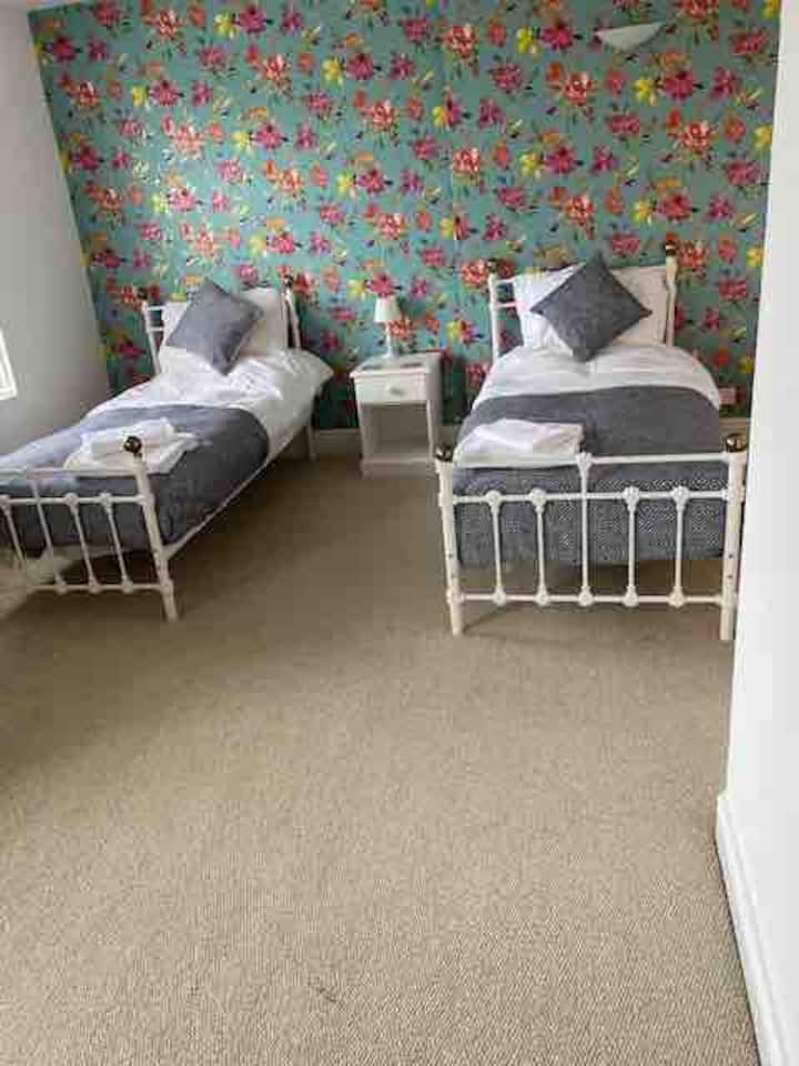 5号卧室：两张单人床、套房淋浴间