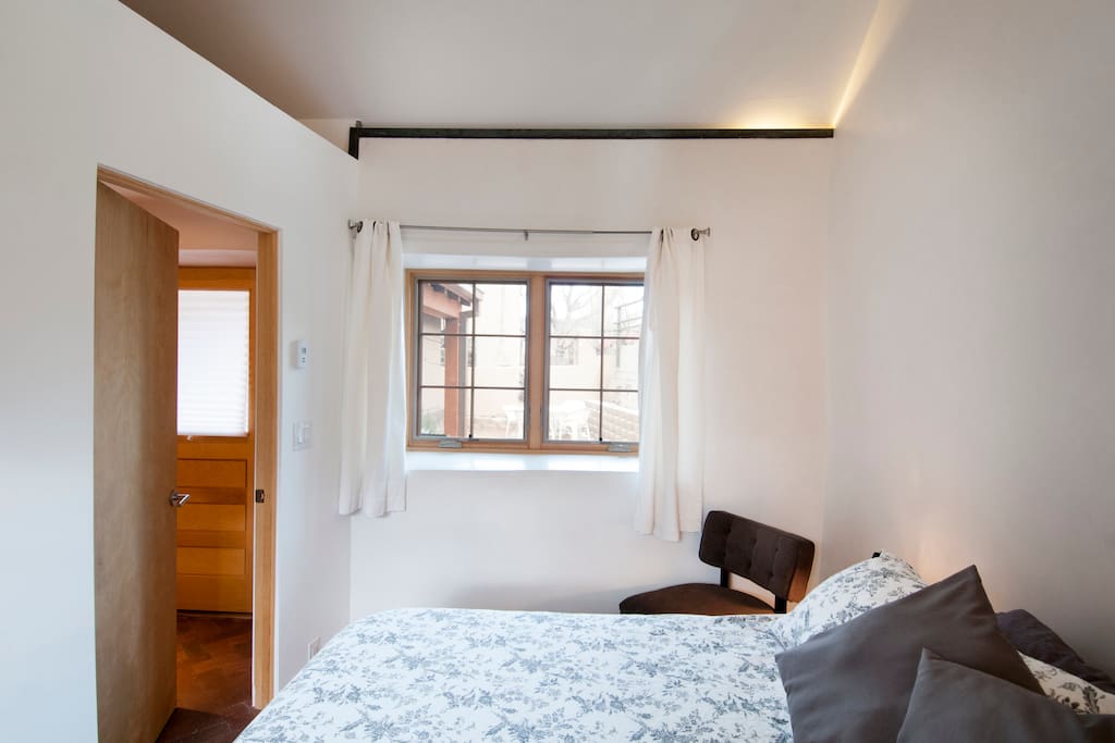 Private Bedroom with King Bed -view through windows are east mountains & front shared courtyard.