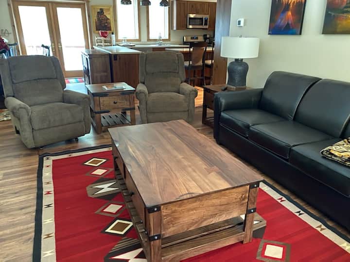 This cozy living room features 2 reclining loungers, a pull-out queen sized sofa bed,  a smartTV for video streaming, board games, and reading materials.