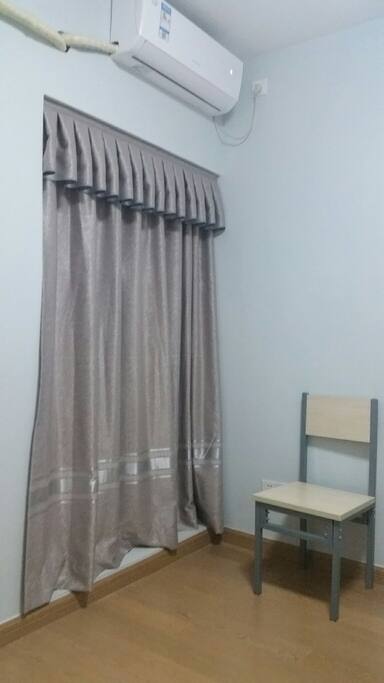 Spare chair, A/C, and a window with a decent view.