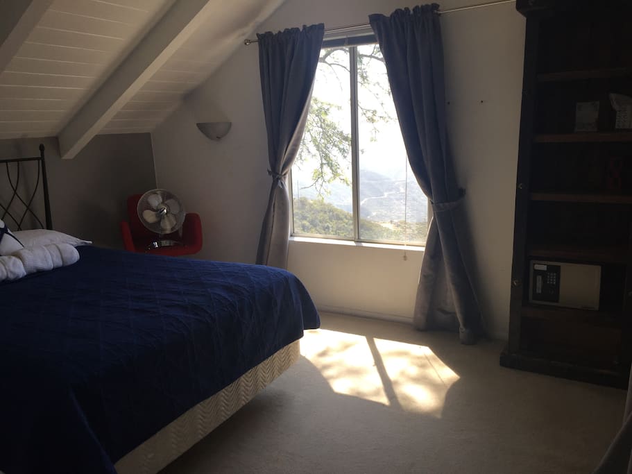 Bedroom with a view and a queen size bed.