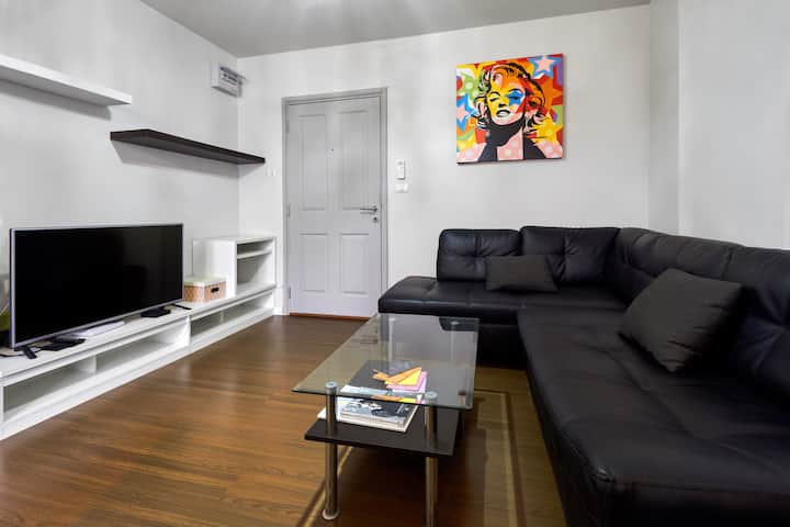 Dhoma e ndenjjes, tavolina prej xhami dhe televizori