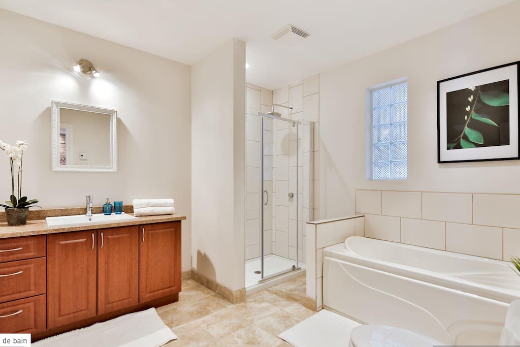 la salle de bain équipée d'une douche et baignoire