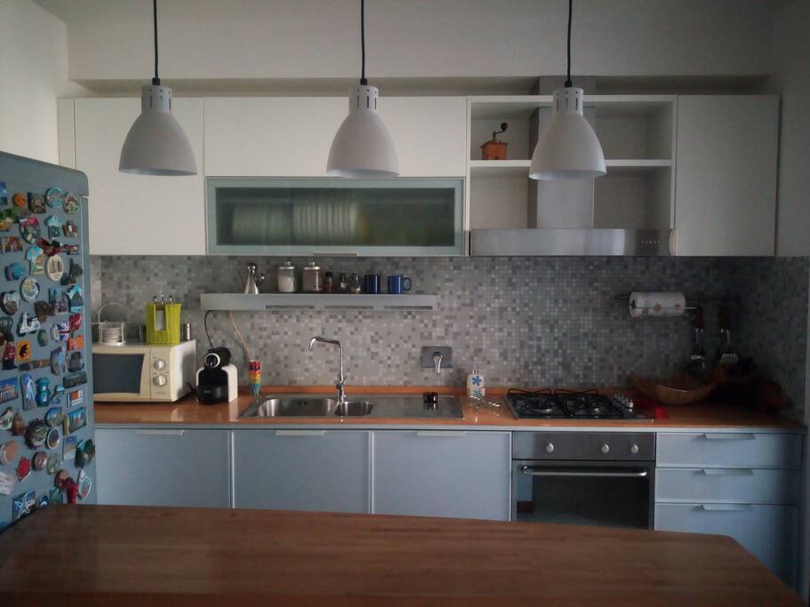 Cucina condivisa con il proprietario dotata di lavastoviglie, forno elettrico, forno a microonde, frigo con surgelatore e penisola per uno spuntino veloce.