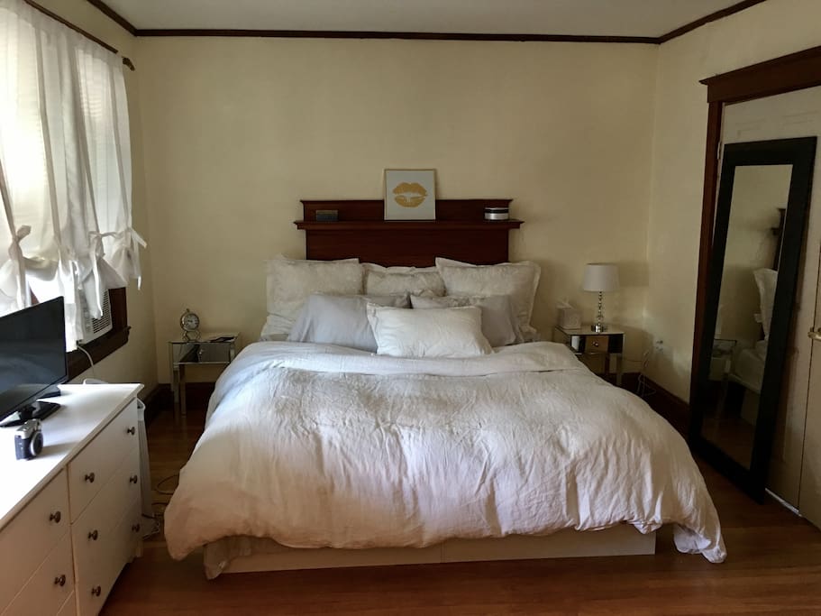 Enter the house into a huge big bedroom! 3 windows! Tons of sunlight! King bed, linen sheets, down pillows, dresser, mirror, tv.