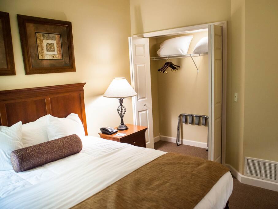 Queen bed with the closet open in the background.