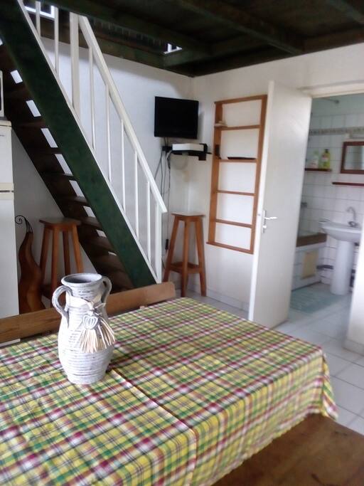 coin repas et salon avec escalier pour accéder à la chambre