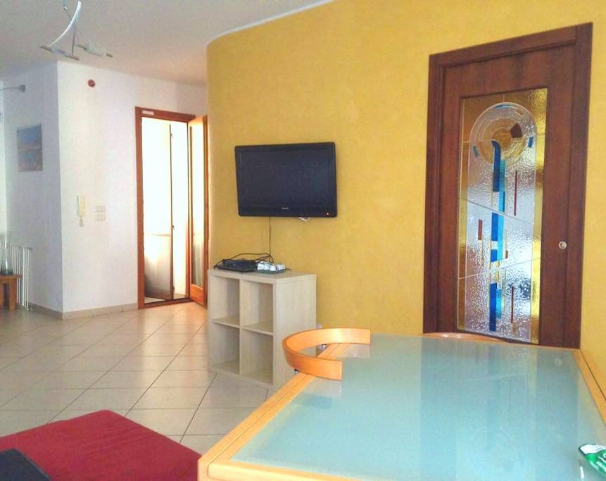 ampia sala con tv, divano, tavolo e sedie