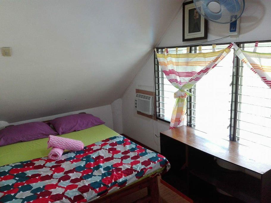 This is your room. It has a double bed, air conditioning and a fan with lots of windows that natural light can come through.