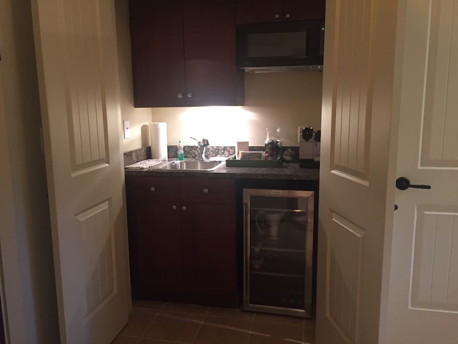 Kitchenette stocked with juice, water, coffee, muffins and fruits.