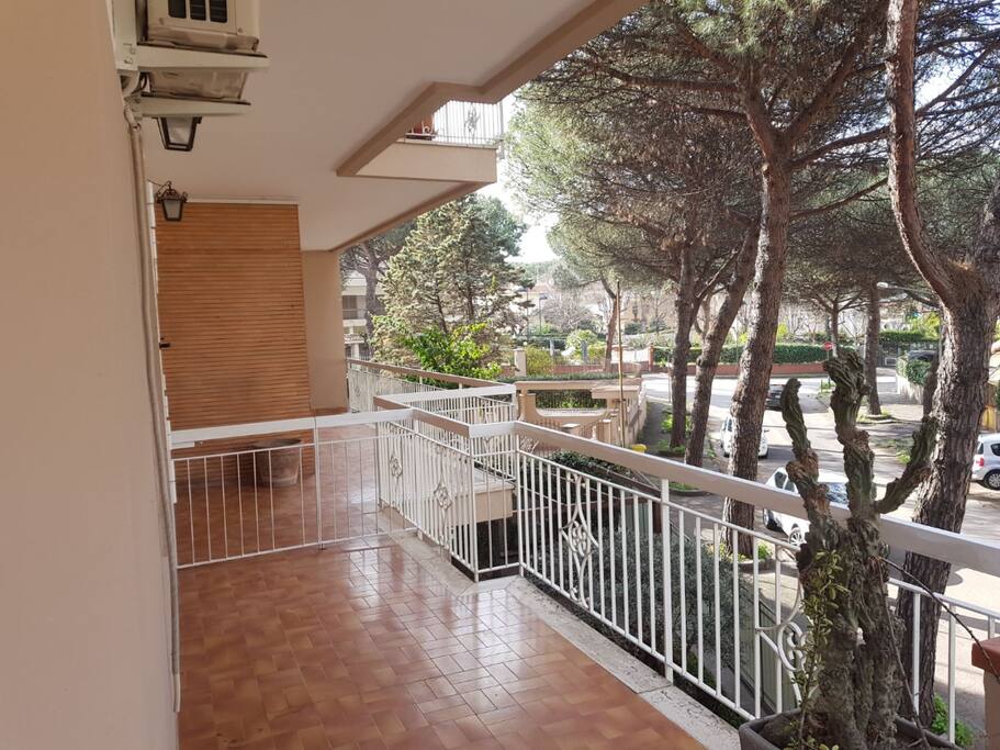 Grande balconata con tavolo e sedie per poter mangiare all'aria aperta.