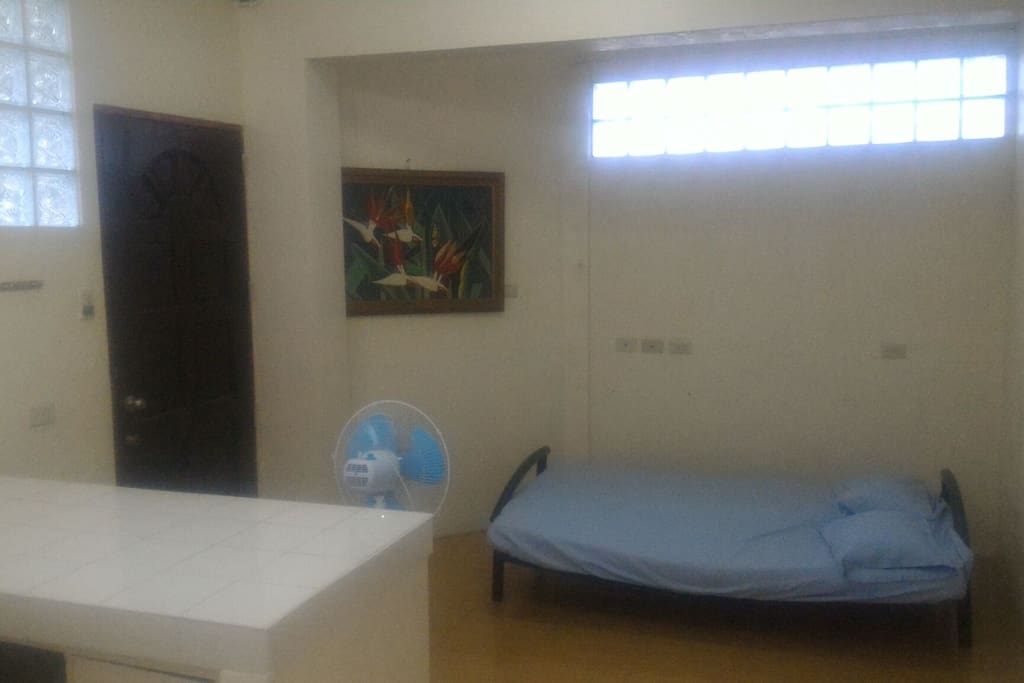 Main door with folding bed and electric fan (this area of the home is non-airconditioned but is cool if airconditioned room is open). 21" LCD TV placed before guest's stay