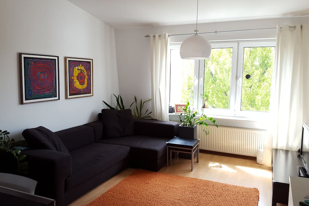 Spacious living room with cosy couch, flat screen TV and cable