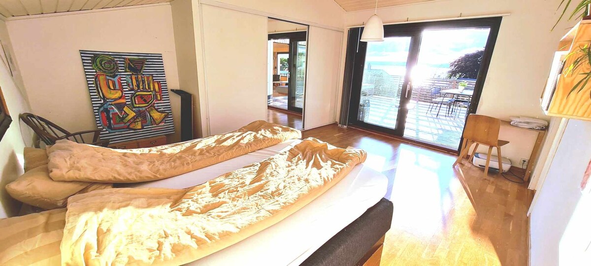 ห้องนอนใหญ่พร้อมเตียงคู่ขนาดใหญ่วิวทะเลและทางเข้าระเบียง