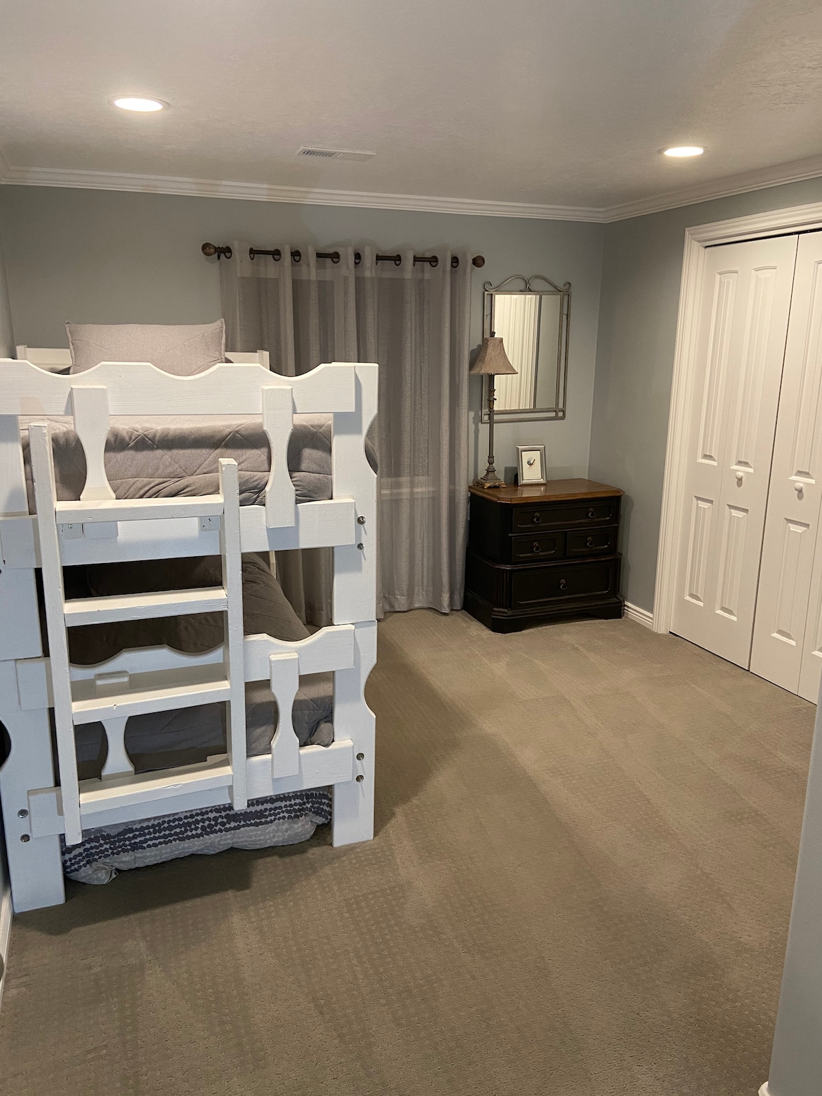 Spálňa 3 s poschodovými posteľami, vytiahnutím matraca pod posteľami a podložkou na spanie v skrini s posteľnou bielizňou navyše.