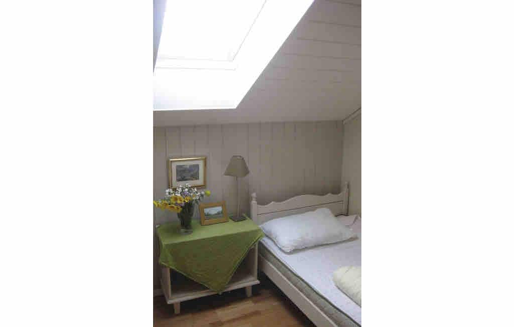 Spavaća soba s krovnim prozorom i dva kreveta za jednu osobu
