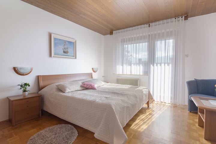 The second bedroom is 15 square meters large and includes a king-size bed (180 x 200 cm), two nightstands with lamps, a large closet with ample storage for clothing, two armchairs and a coffee table.