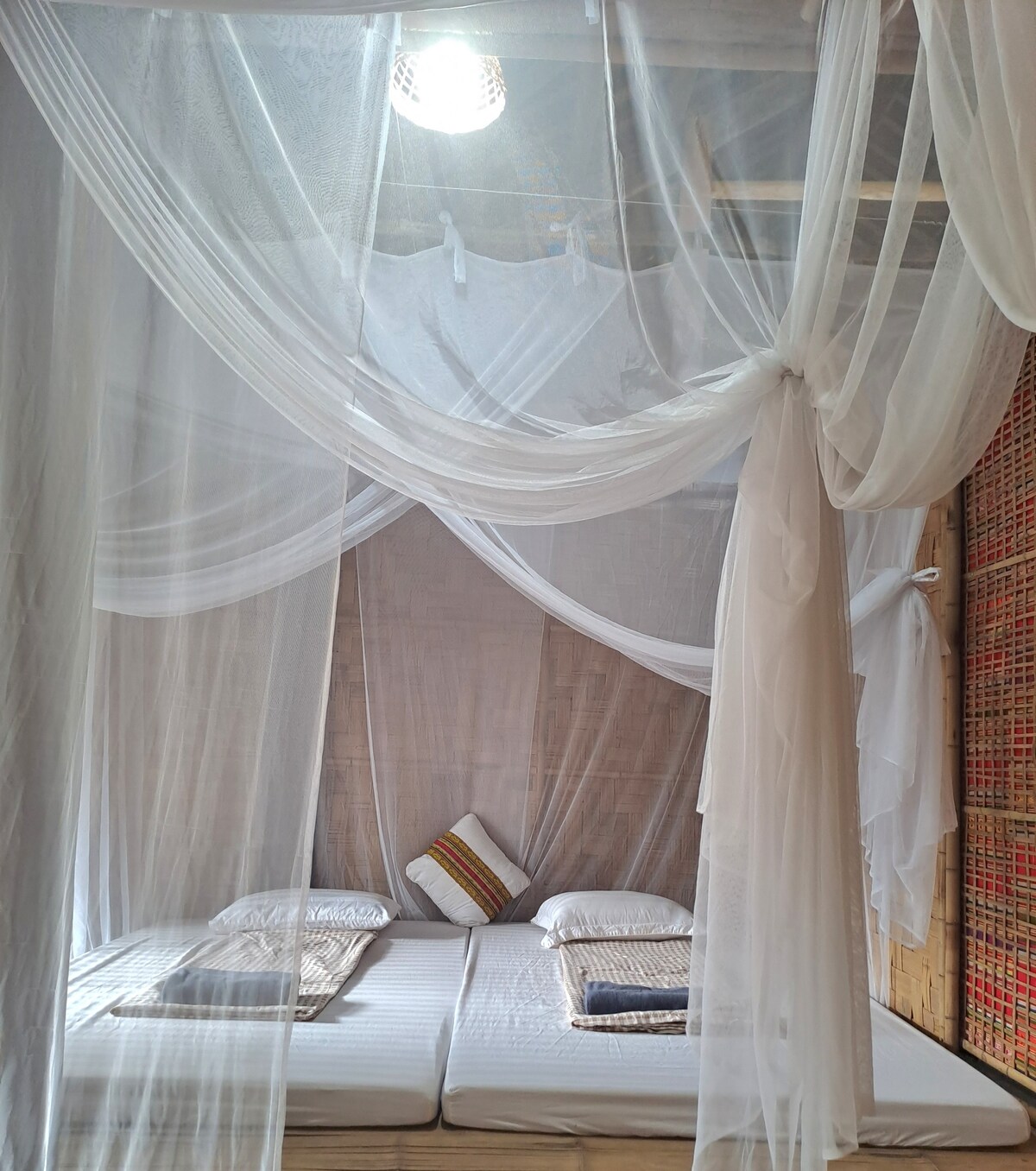 A double room is a simple, small bedroom with 2 single mattresses or 1 double mattress. The room has clean blankets, sheets, pillows, mattresses, fans and mosquito nets. A small balcony with tables and chairs.