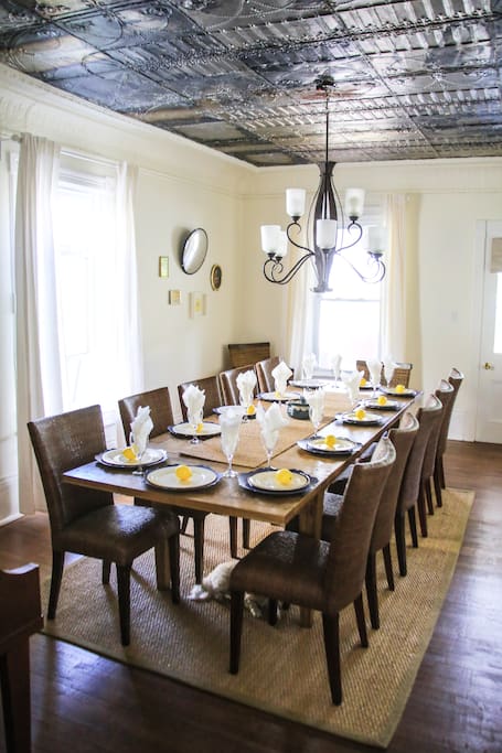 Formal dining room seats 12 on beautiful hand made wooden dining set. Freshly uncovered original tin ceiling.
