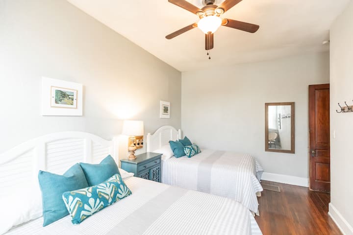 Dormitorio en el primer piso con dos camas tamaño matrimonial.