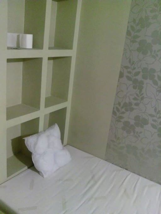There are bed, shelf, drawer and small bathroom with sink, toilet and shower upstairs on the gallery.