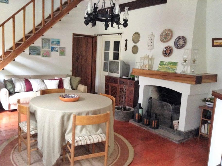 Na sala de estar destaca-se a escada em madeira que permite subir ao primeiro andar, onde se encontram dois dos três quartos de dormir. Another view of the living room, especially the wooden staircase to the first floor where are the two of the three bedrooms in total.