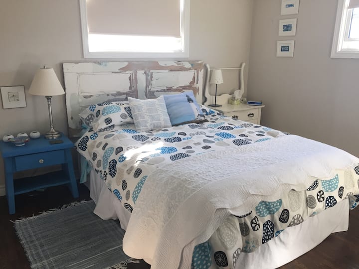 Chambre principale : la tête de lit est une porte récupérée d'une maison déchirée à Duntara (lit queen size). Placard et commode et deux fenêtres pour obtenir une belle brise et une lumière matinale. Des stores occultants si les matins ne sont pas votre truc.