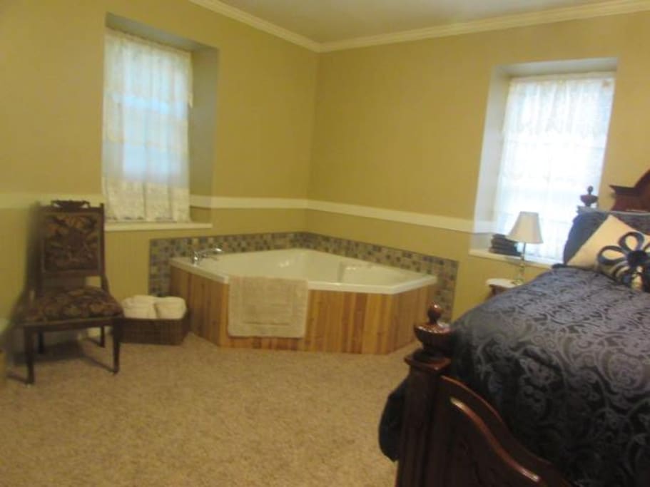 corner whirlpool tub for two, bath salts in room.