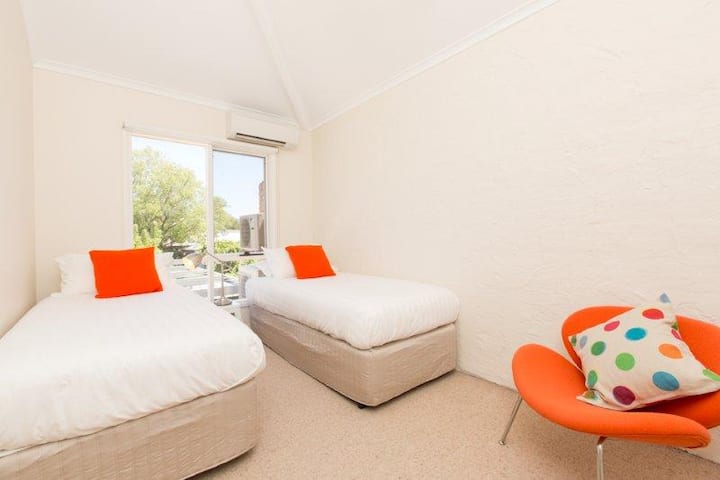 غرفة نوم تضم سريرين صغيرين 