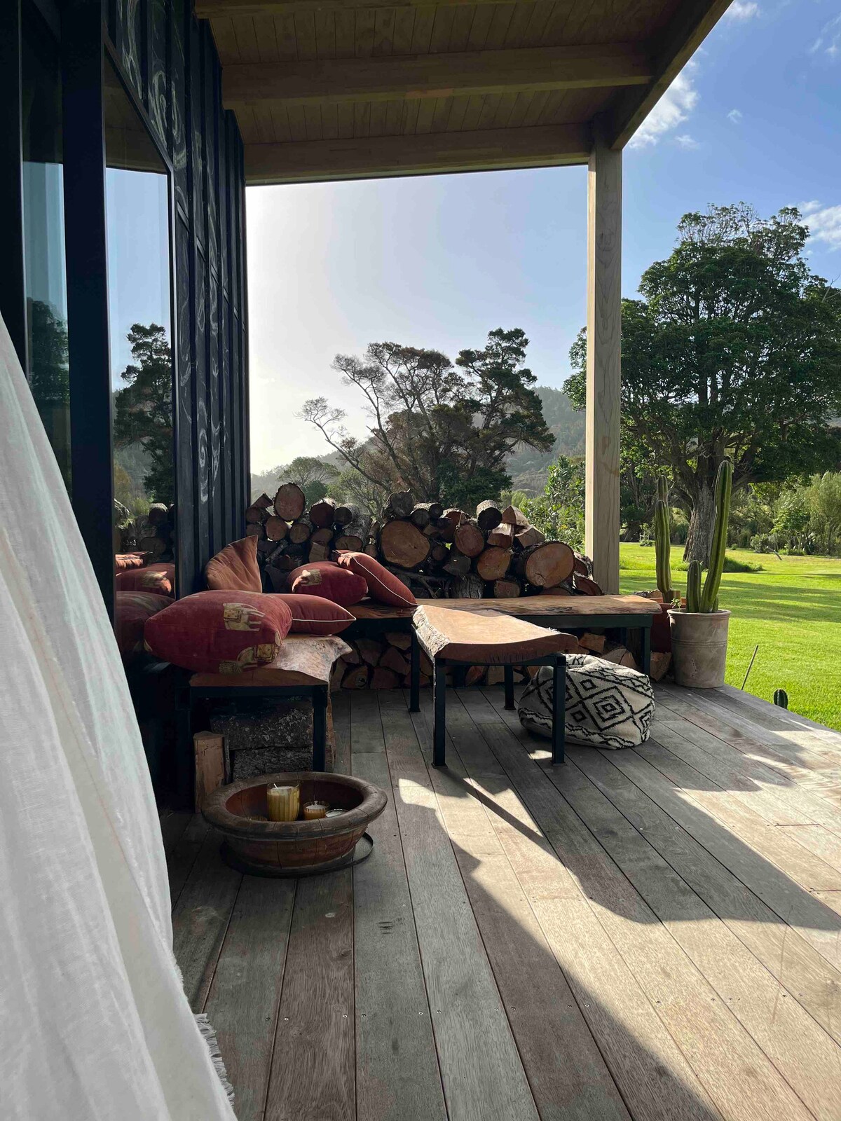 Large deck overlooking peaceful green nature area with a stream at New Chums in Whangapoua