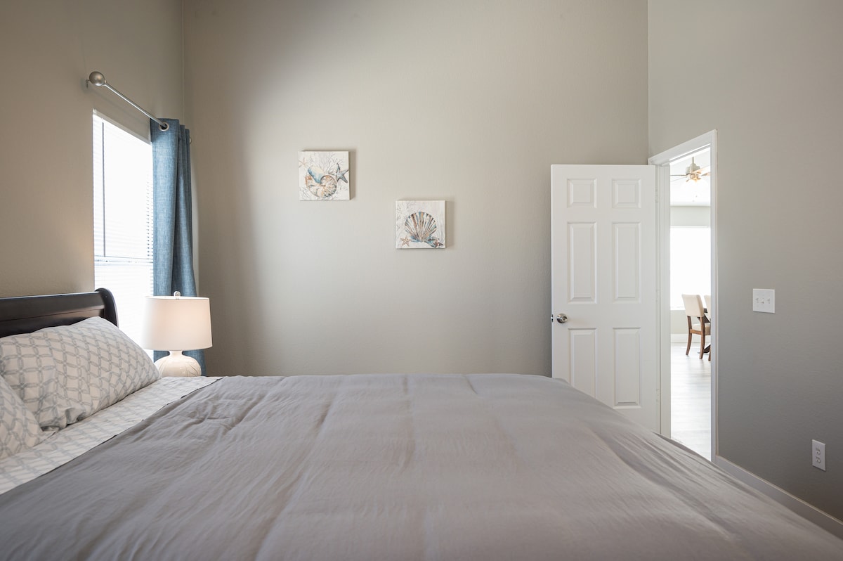 غرفة نوم رئيسية واسعة بسرير بحجم كينج وحمام خاص ملحق.