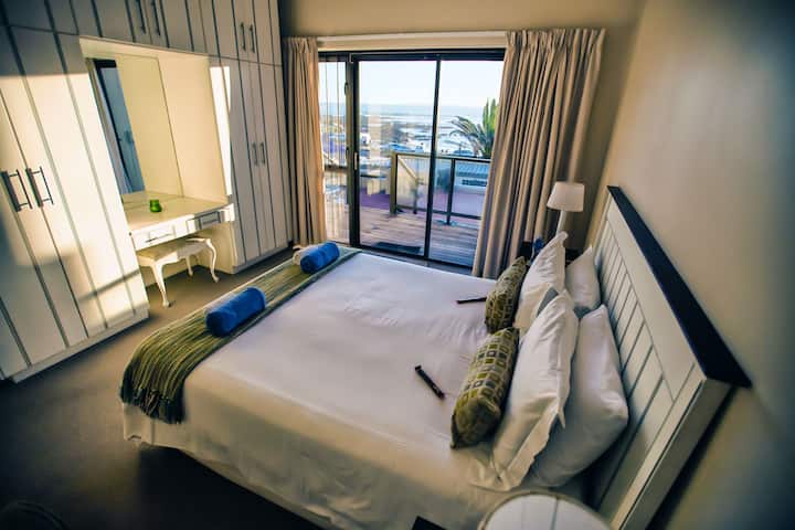 Свртена кон морето спална соба за гости со станица за шминкање.