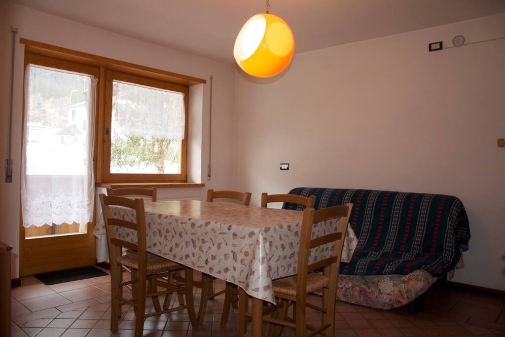 Zona giorno con tavolo da pranzo e divano letto