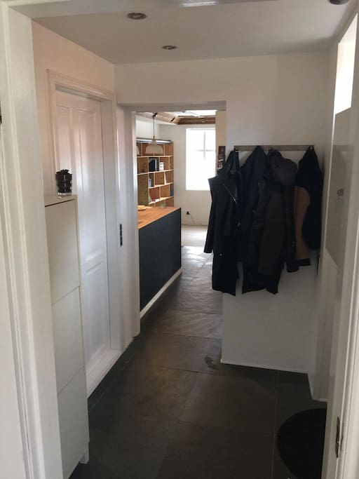 Entré med dør til toilet, køkken og stue ligefrem. Billedet er taget fra døren til soveværelset
