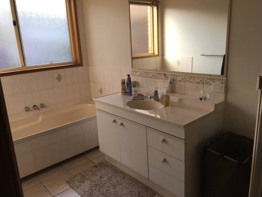 Airy bathroom with bath and shower. Loo close by and separate.